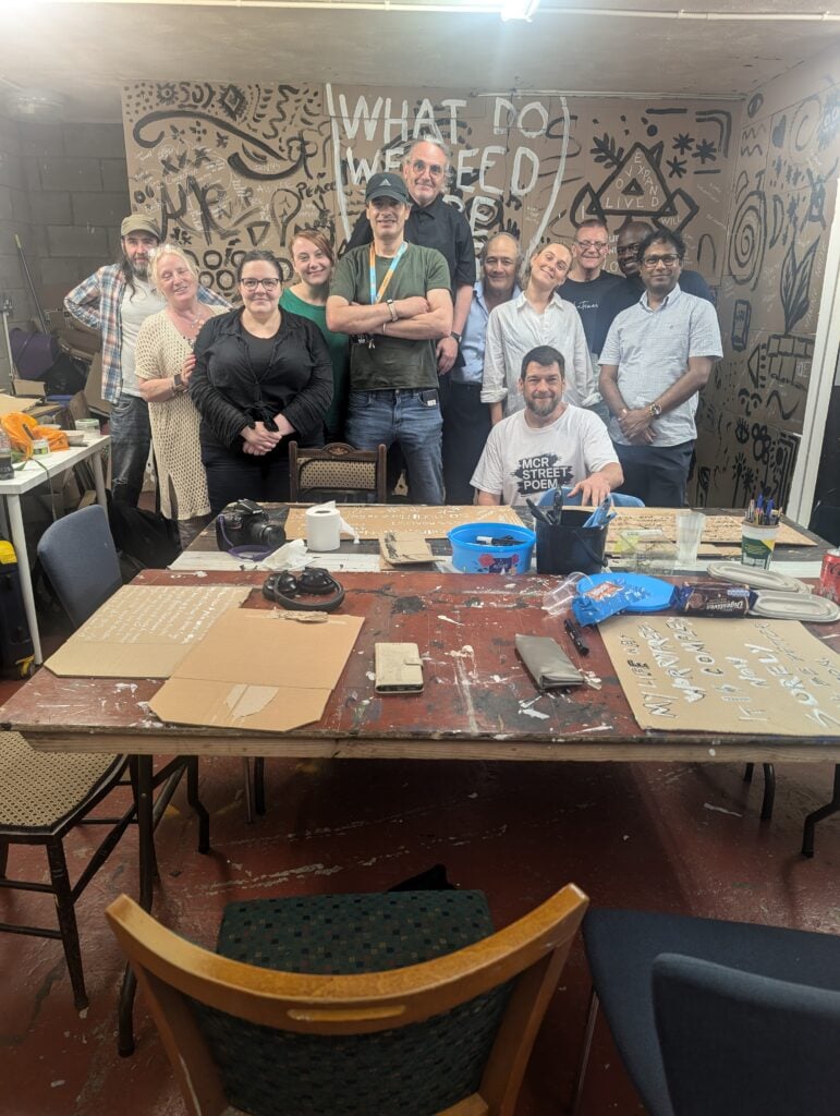 A group photo of reporters stood around a desk during a workshop.
